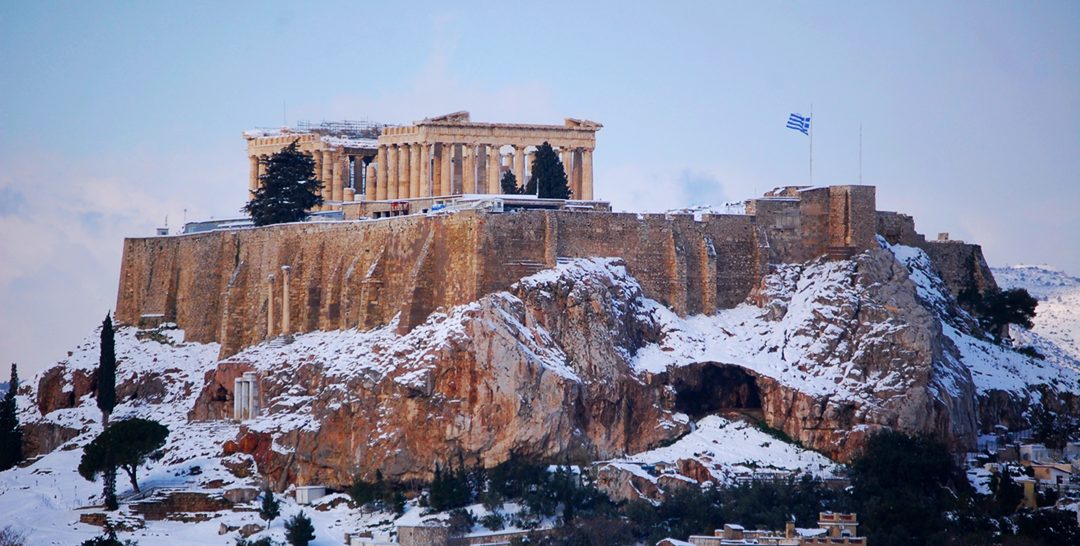 Parthenon in Athens, Greece surrounded by snowy mountain
