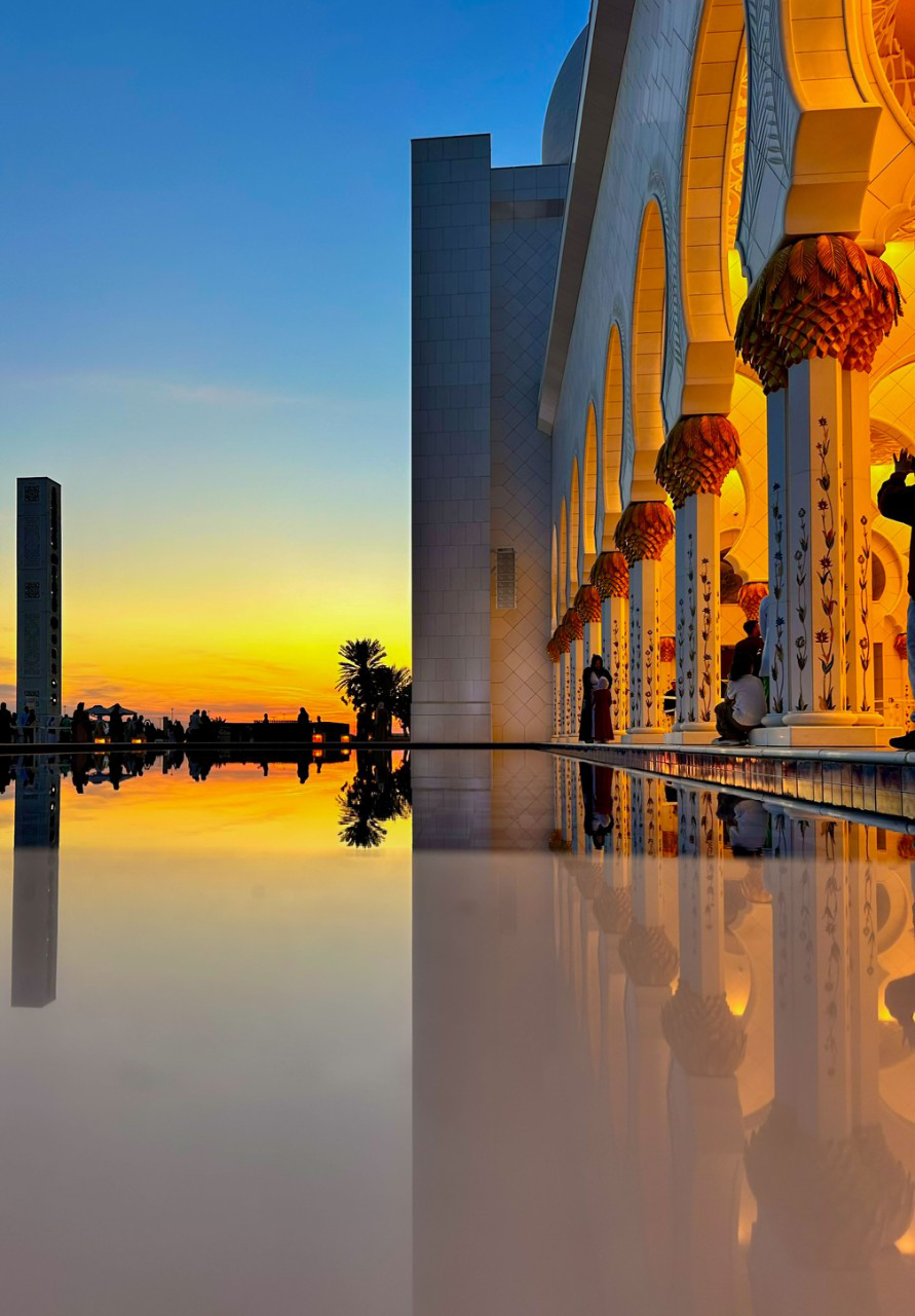 a mosque with reflection of a sunset on the marble floor