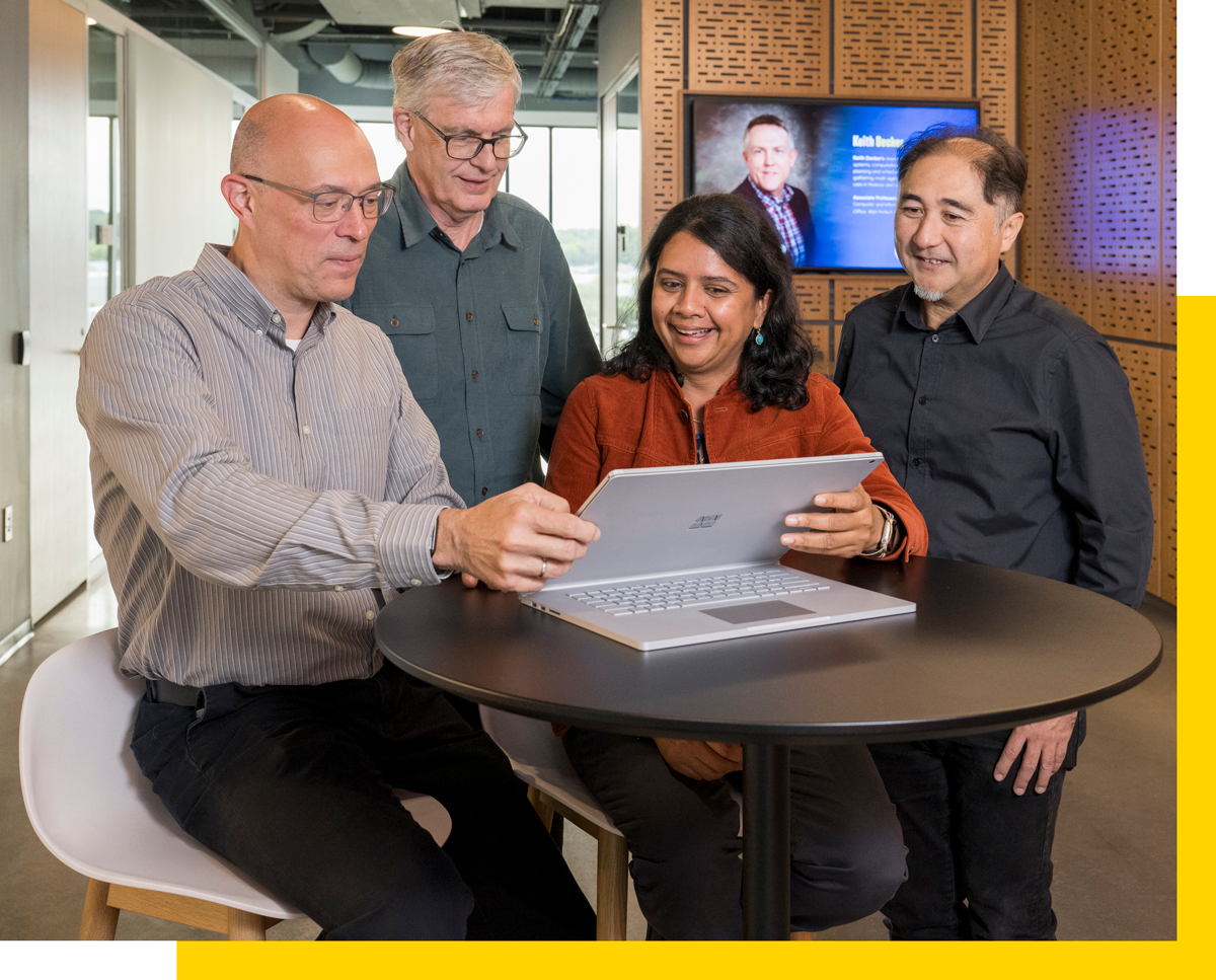 UD Experts Various UD Faculty looking at a tablet and smiling.
