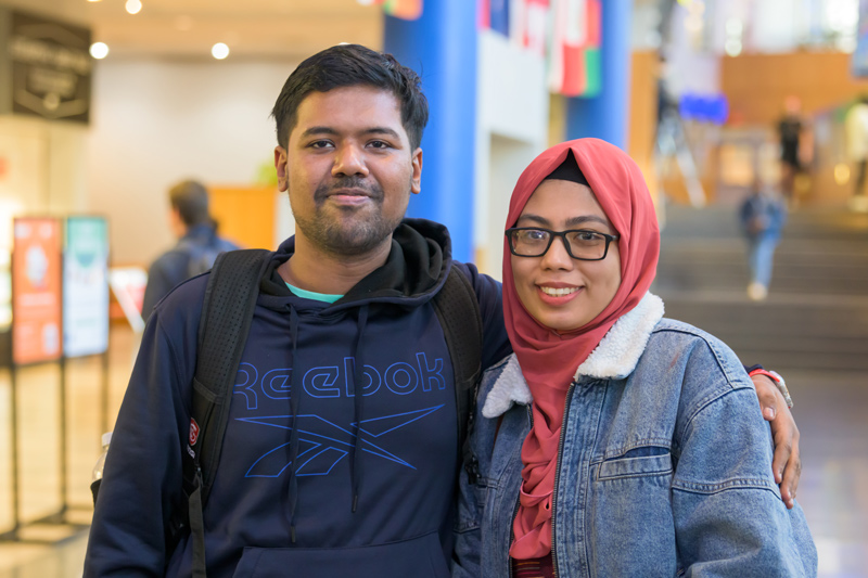 Two students smile for a photo at an International Coffee Hour event
