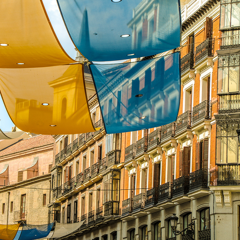 马德里太阳广场（Plaza del Sol），蓝色和金色旗帜悬挂在街道上。 
