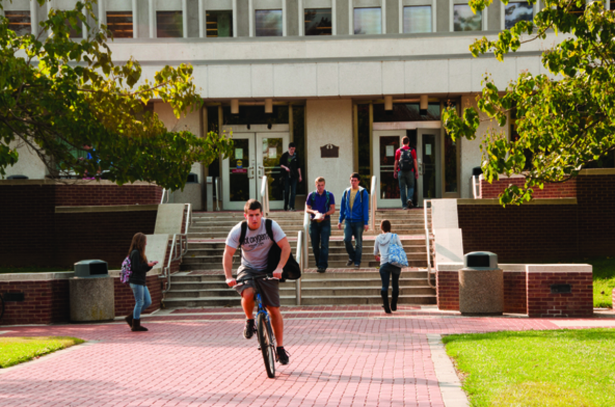 Students walking and biking outside of Morris Library