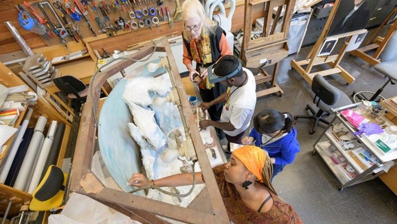 TIP-C students cleaning the Matthew Henson diorama
