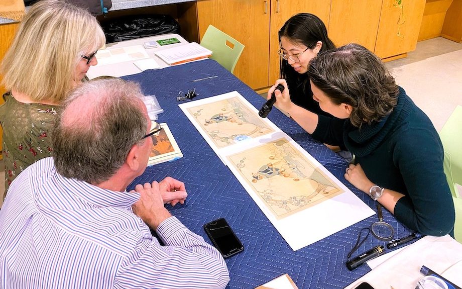 4 people examining prints 4 people examining prints