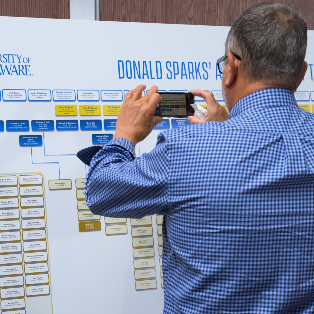 A gentleman photographing part of the Don Sparks Family Tree.