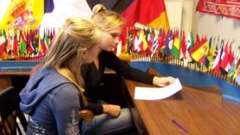 Two female students conversing at a table