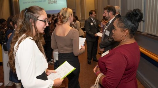 Two female students conversing at a table