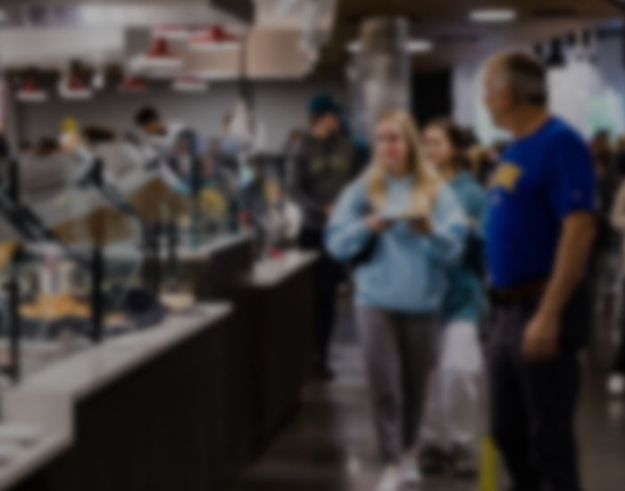 a student carries food on a tray through the Rodney Dining Hall