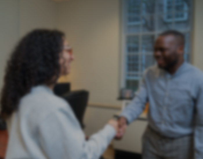 a staff member shakes hands with a student