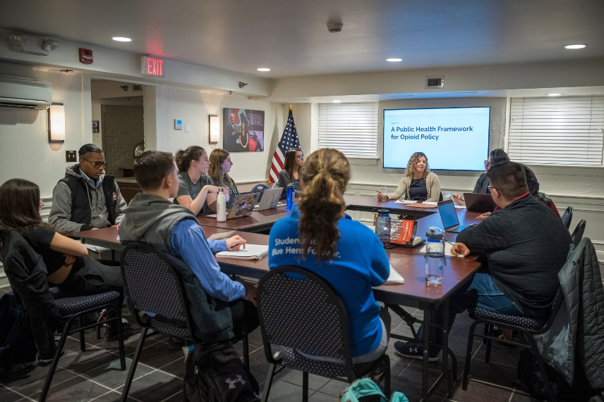 Photo of substance use policy researcher Kayla Tormohlen immersed in discussion with students during a Biden Institute opioid epidemic policy seminar