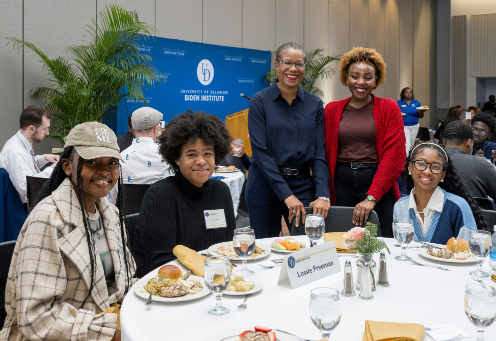 Photo of students gathered together smiling at a table during the 2024 Biden Institute Black History Month dinner event