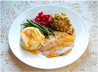 A photo of a plate of holiday foods including turkey