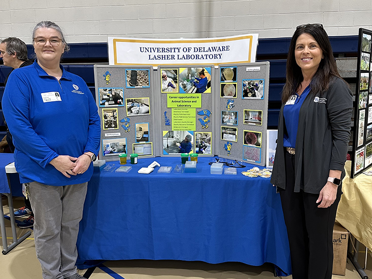 Lasher staff by a booth at a school career day