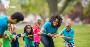 Two adults are playing tug a war with children