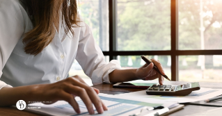 a woman at her desk with a calculator and financial papers