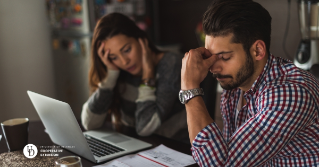 A couple in distress as they look at their bills and computer