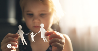 a child with a concerned look holding a paper cutout of a family