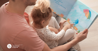 A father reading along with his child