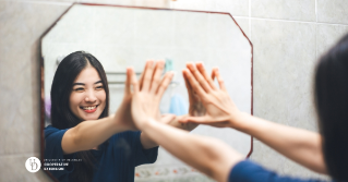 A female teen looking into the mirror smiling