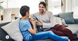 a father and a son on the couch talking