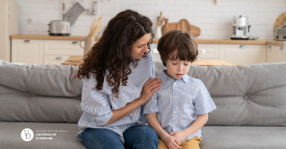 A mother sitting with her young son comforting him