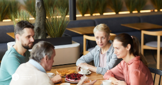 Four family members together talking at a table