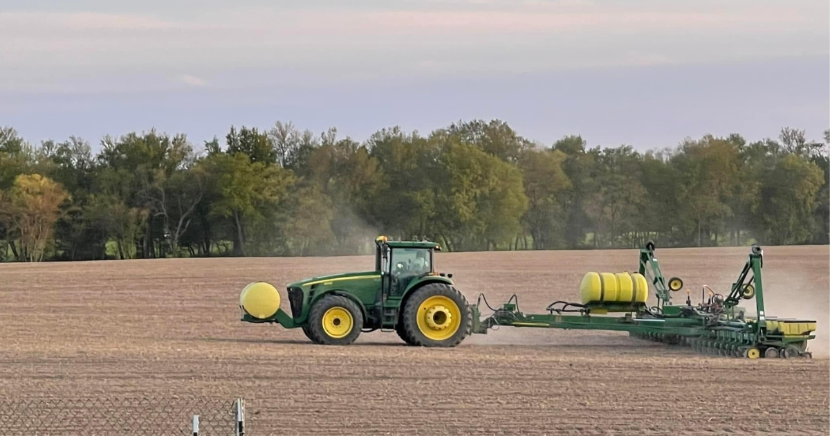 A tractor in a field planting corn A tractor in a field planting corn