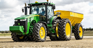 A tractor in a field planting corn