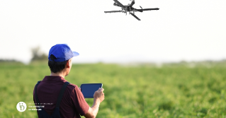 A man flying a drone over a field