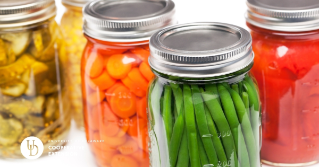  A photo of 5 jars filled with fruits and vegetables