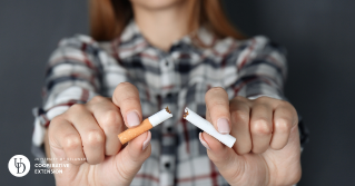 A female teen breaking a cigarette in half