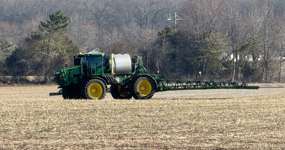 A tractor in a field applying lime A tractor in a field applying lime