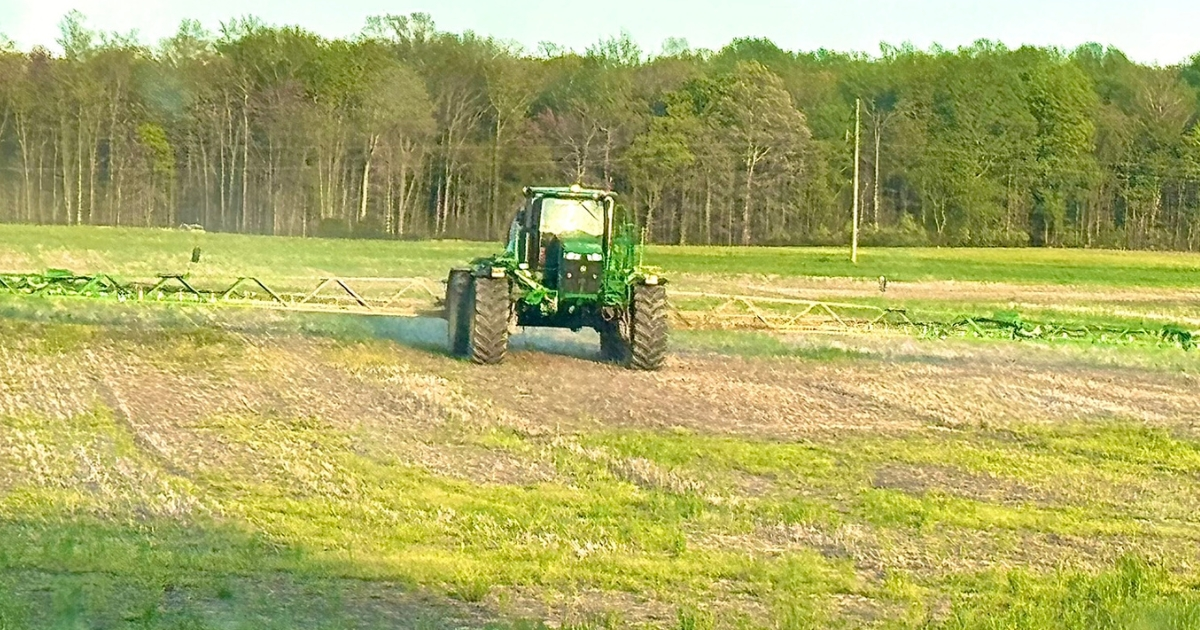 A tractor in a field applying lime A tractor in a field applying lime