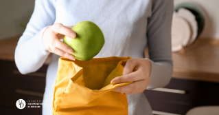 A woman packing an apple in her lunch bag