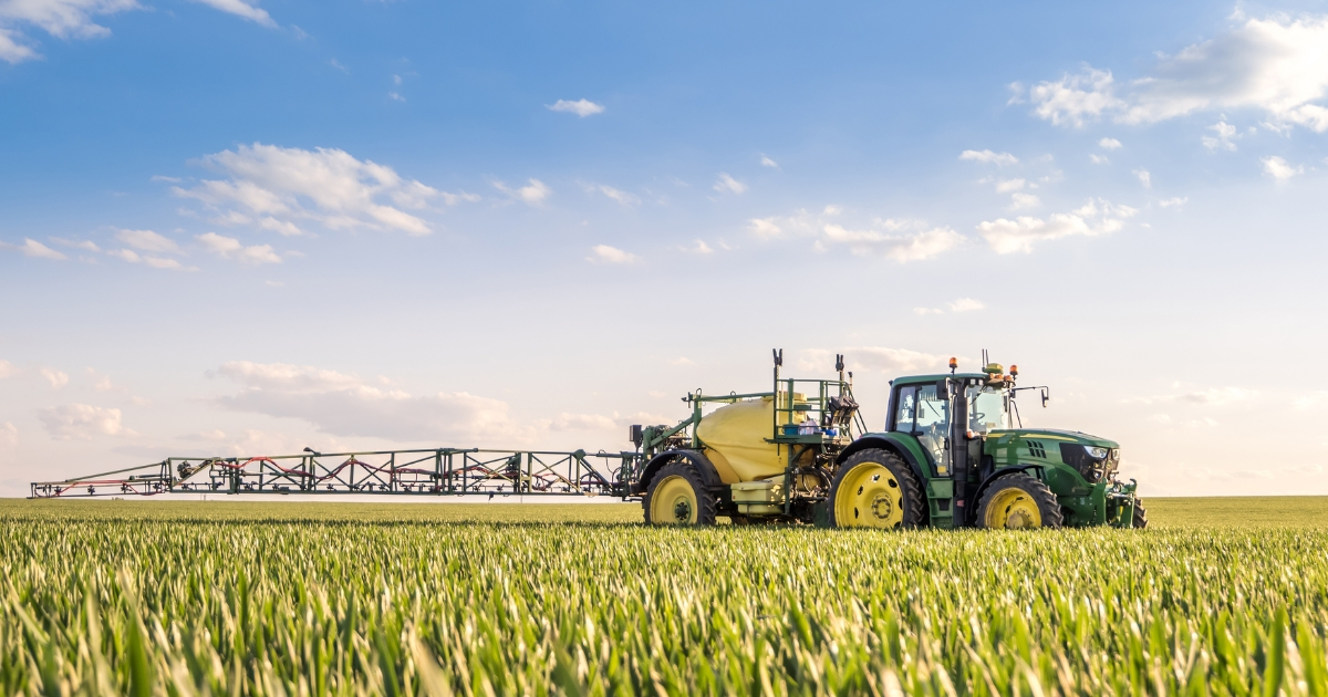A tractor spraying a substance in the field A tractor spraying a substance in the field