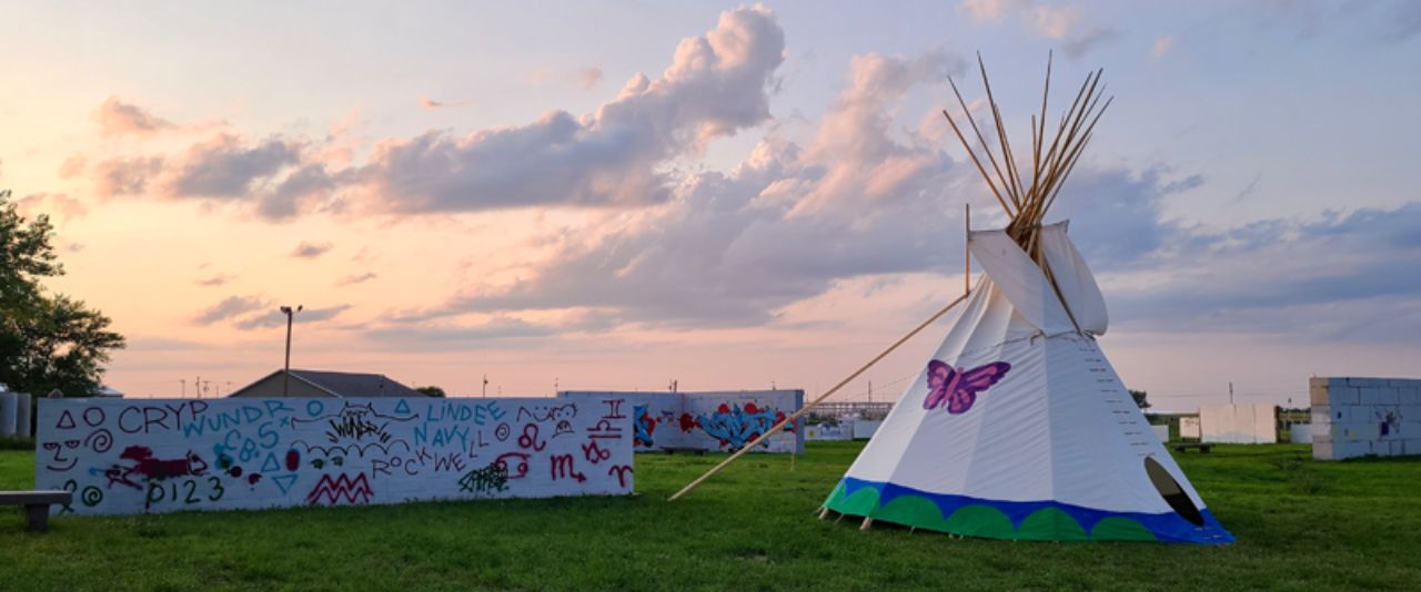 tipi and painted walls in Waniyetu Wowapi Art Park, Eagle Butte, South Dakota