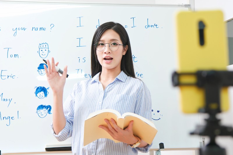 Asian female teacher in a classrom teaching Chinese language