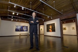 Paul Jones standing in a suit with arms across in Mechanical Hall art gallery