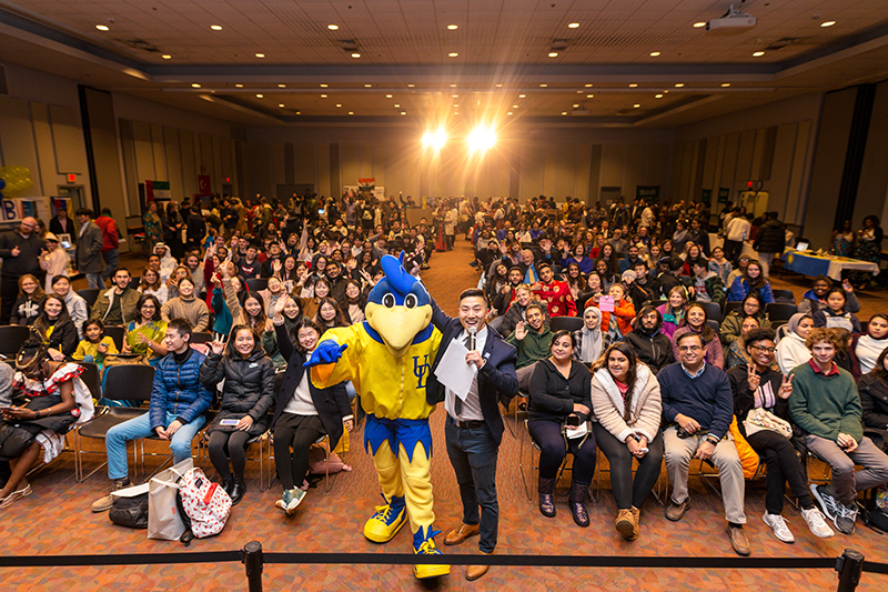 An audience inside Trabant University Center pose for a group photo with YoUDee during an event.