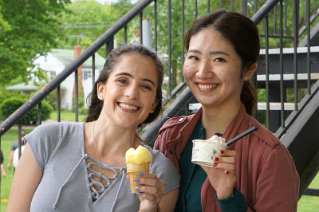 Two smiling college students holding ice cream.