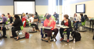 Group of educators sitting at desks in circles discussing problems