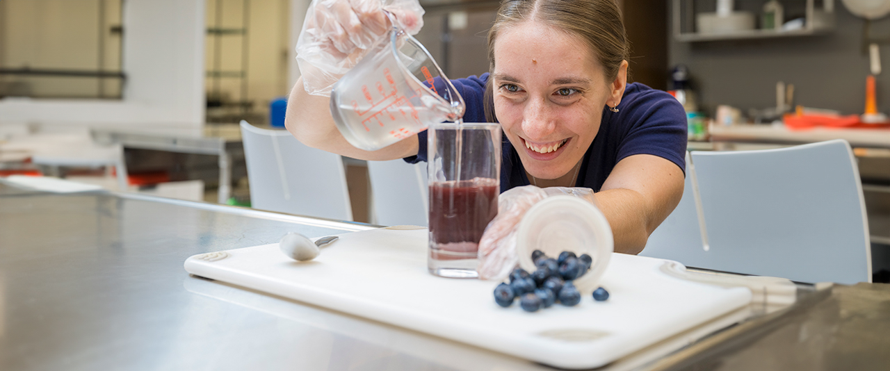 Dietetics senior preparing blueberry powder in the test kitchen for a research study