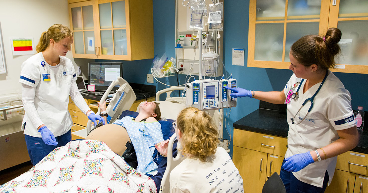 Nursing students take part in a maternity simulation. 