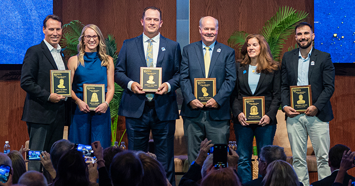 The 2024 Athletics Hall of Fame inductees were honored during an October 2024 ceremony.  Here the six inductees are posing with plaques. Three of the six graduates are alumni of the College of Health Sciences.