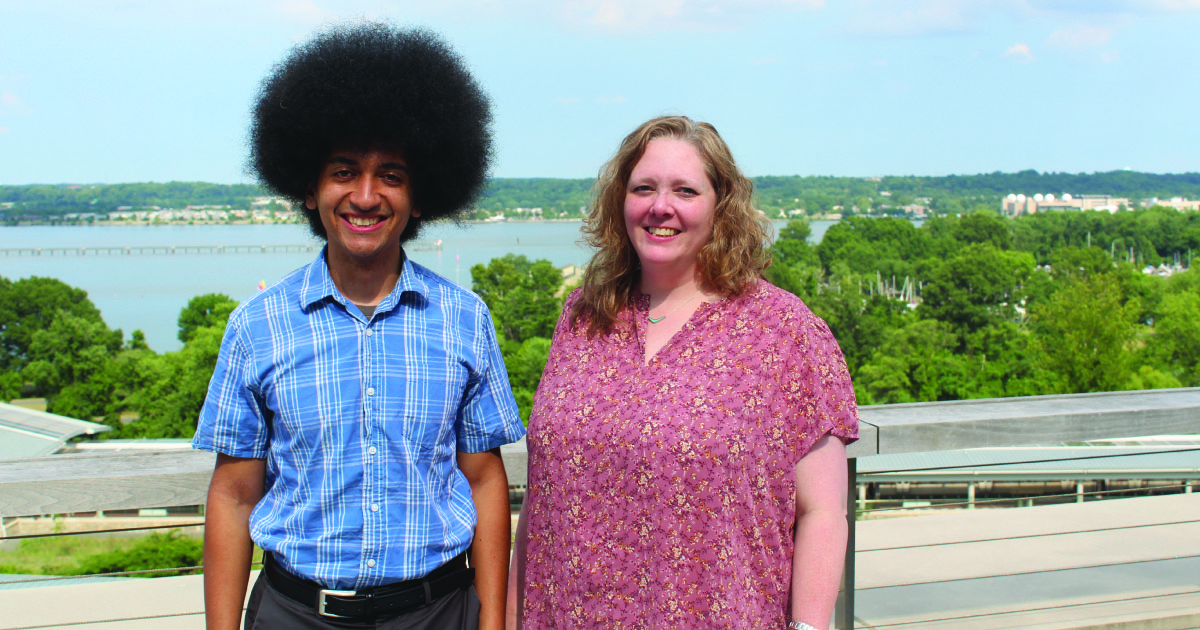 A young man student and woman professor posing in front of a road