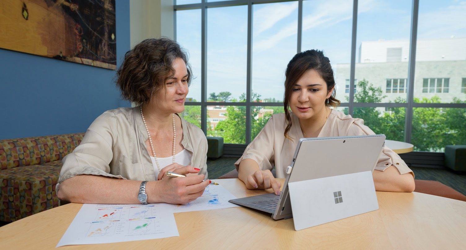 Professor Cristina Archer sits with a student