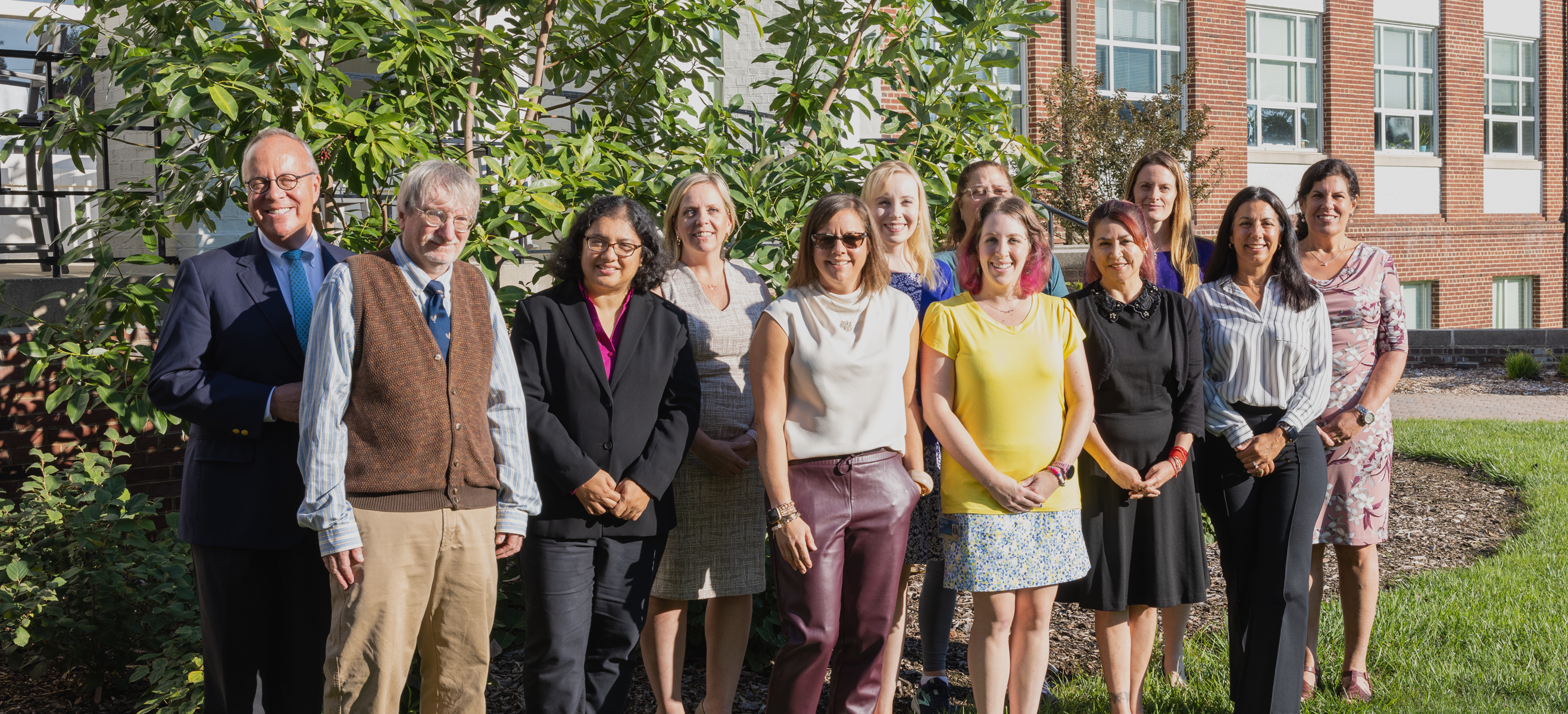 Group shot of faculty senate award winners from last year, posing in front of a campus building.