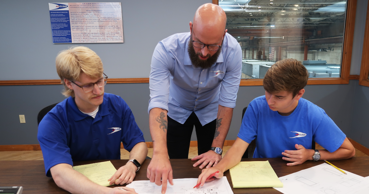 Air Clear employees huddle at worktable