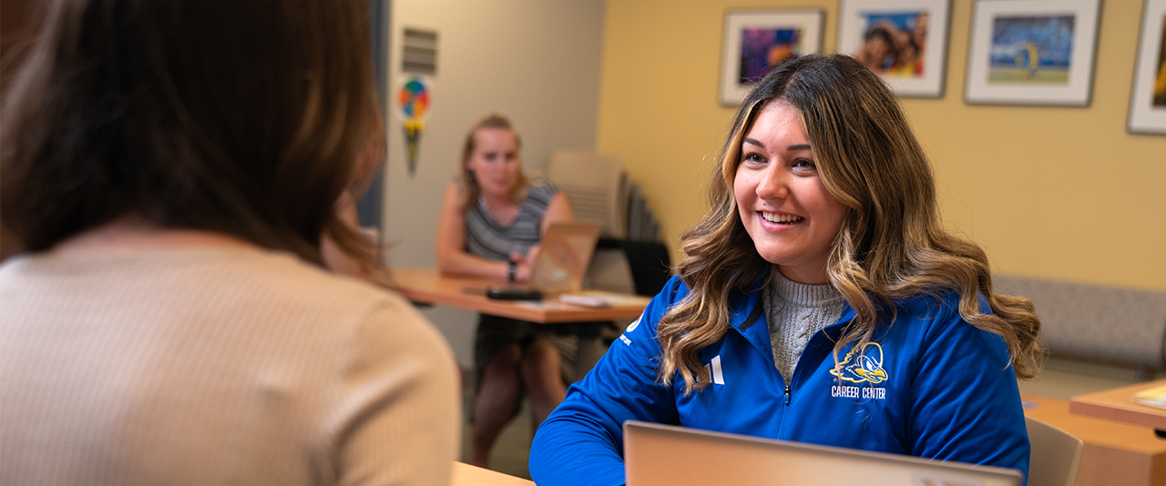 A student meets with a peer advisor during a drop-in resume review