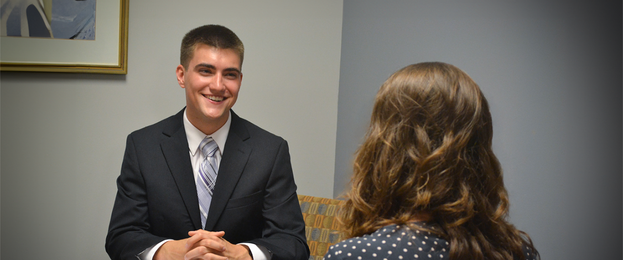 Student in a suit and tie interviewing with an employer